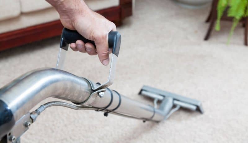 Steam cleaner in action removing dirt and odours from home carpet
