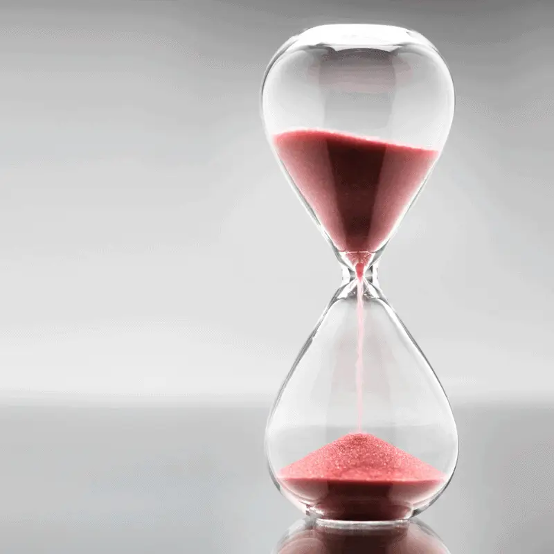 Glass hourglass with red sand symbolising time-based cleaning services – Easy Bliss Brisbane